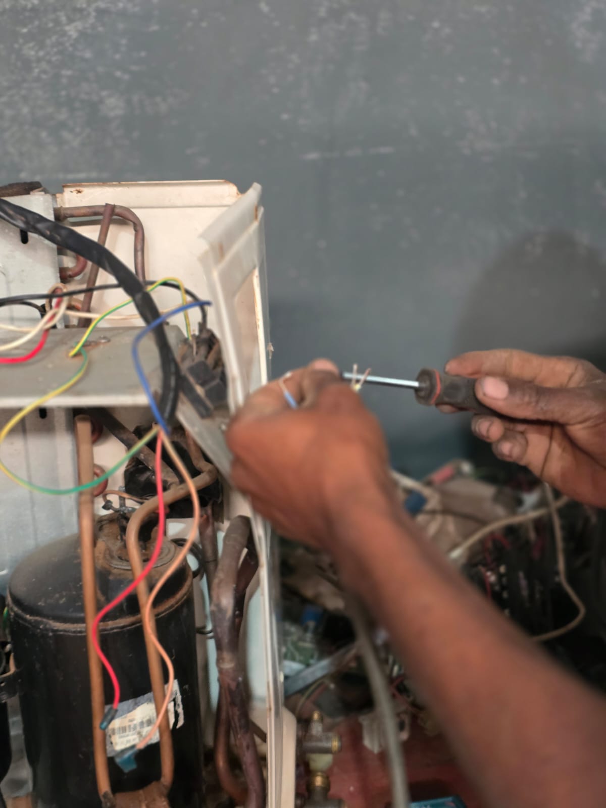 Technician working on the wiring of an air-conditioning unit