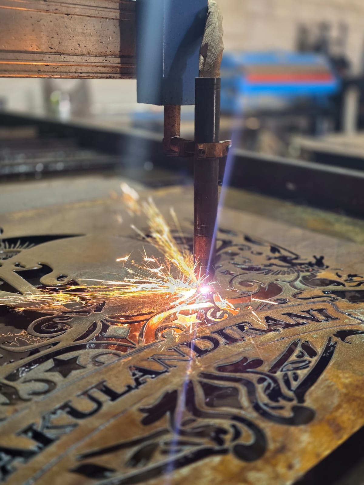 Plasma cutter cutting a decorative 'Kulandirani' steel welcome sign