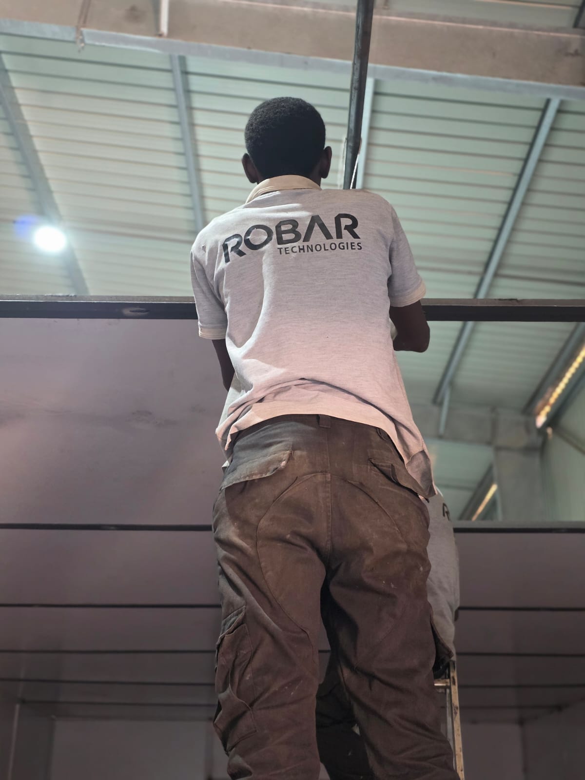 Robar Technologies worker installing structural steel at a building's roofline