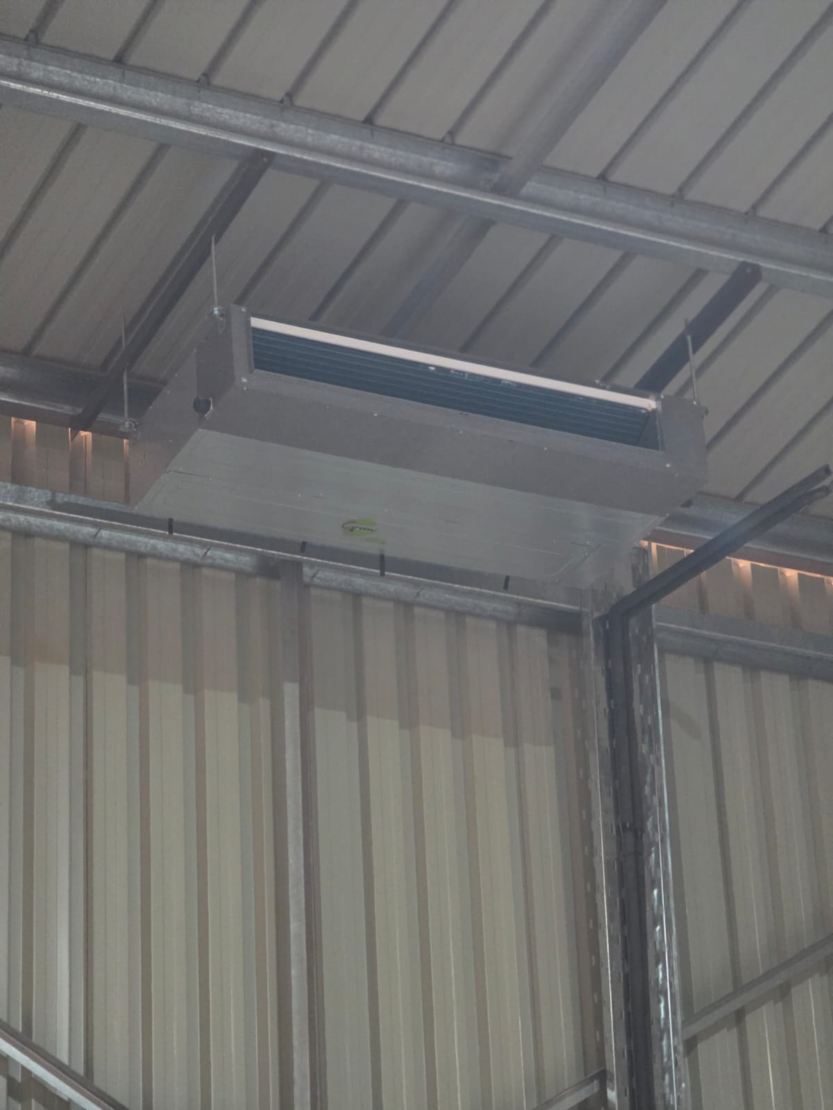 Ceiling-mounted ducted fan-coil air-conditioning unit installed in a steel building