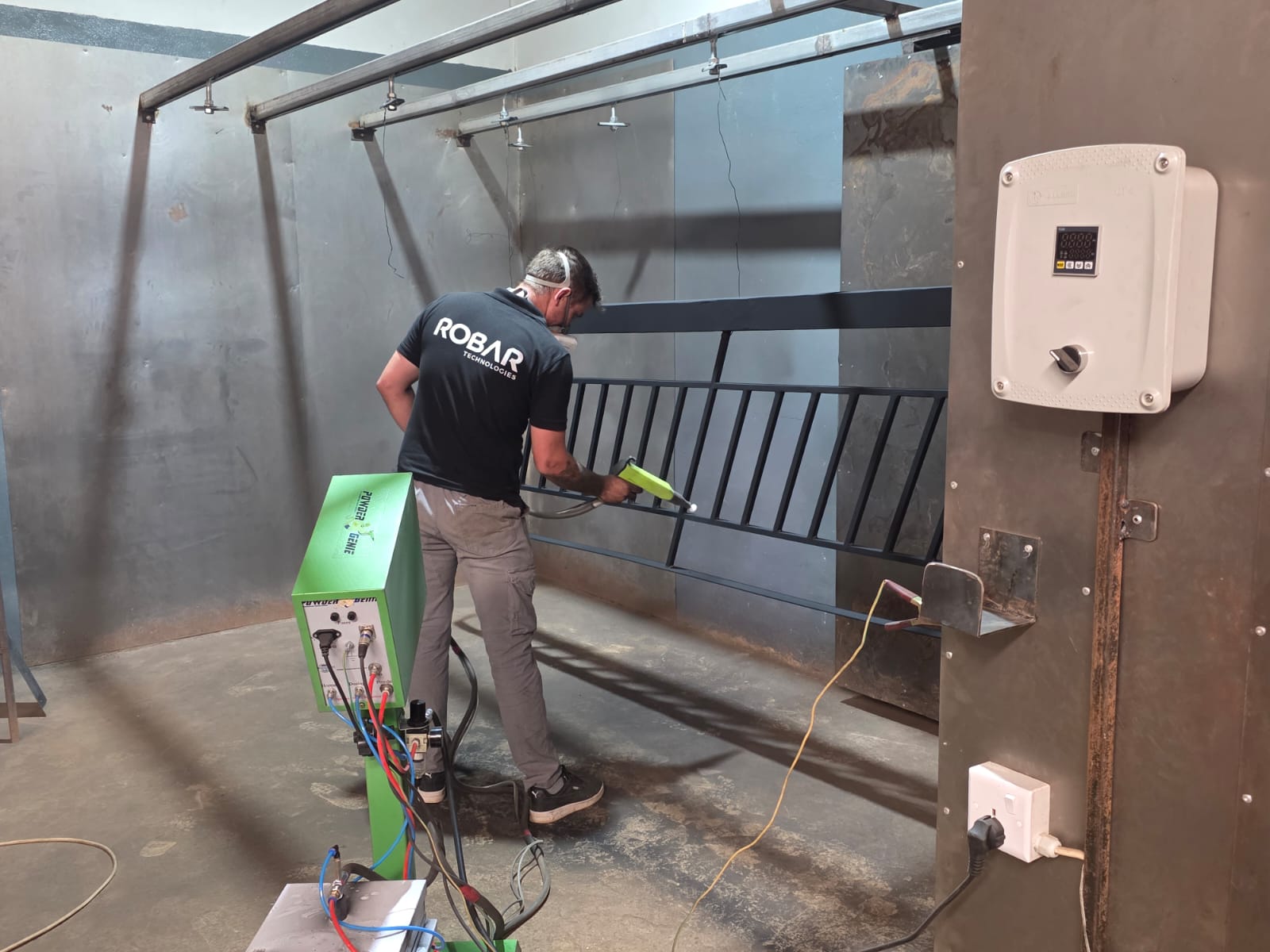 Robar Technologies applying powder coating to a steel balustrade in the spray booth