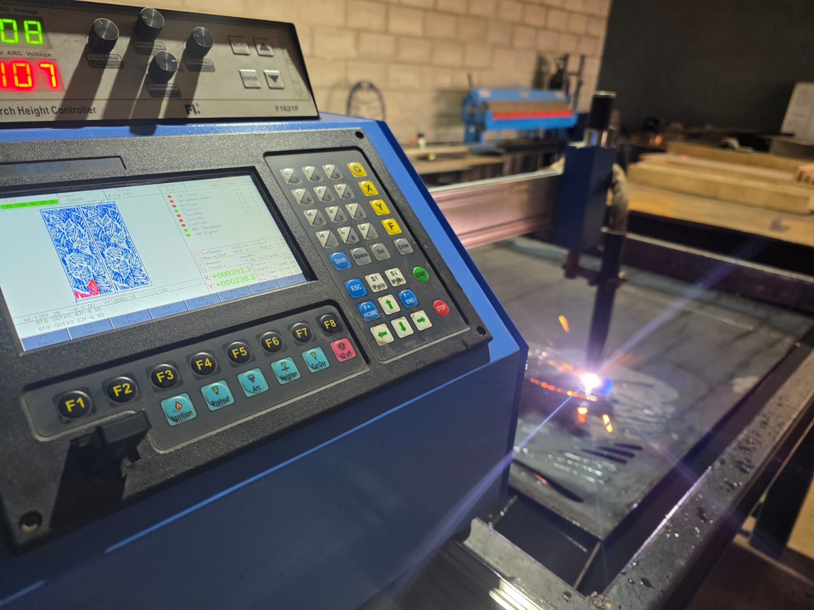 CNC plasma cutting machine control panel and cutting table in operation