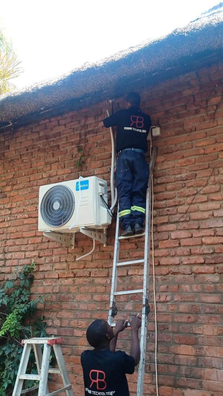 Robar Technologies team installing a split air-conditioner on a brick wall